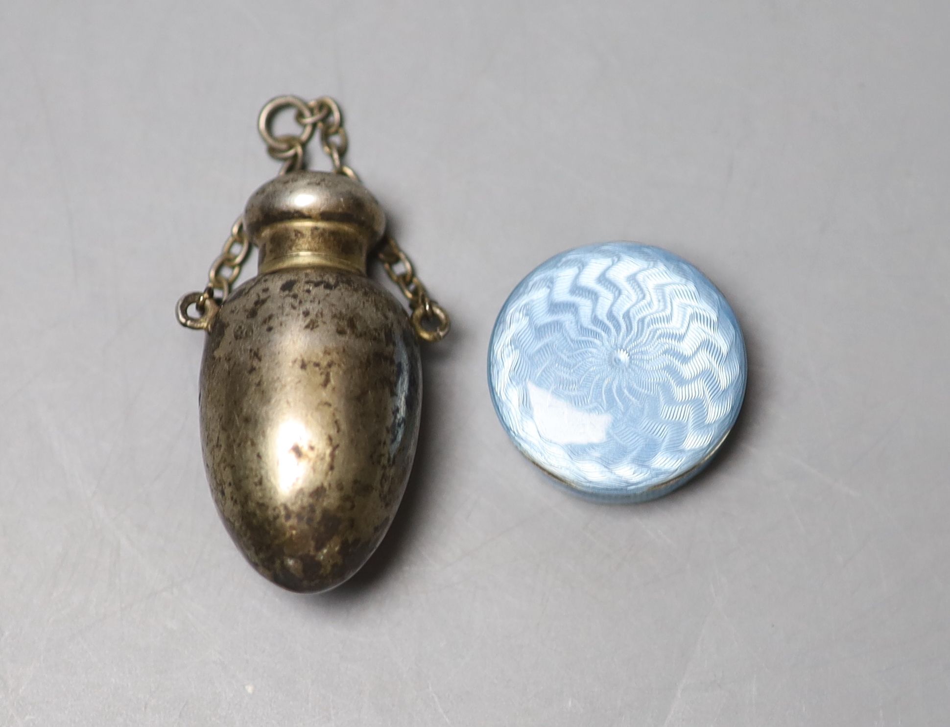 A late Victorian silver egg shaped scent bottle, Birmingham, 1900, 51mm and a 1920s silver and enamel pill box.